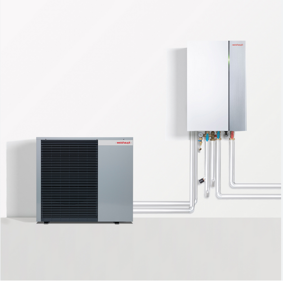 Pompe à chaleur grise et unité murale blanche reliées par des tuyaux blancs sur un mur blanc.