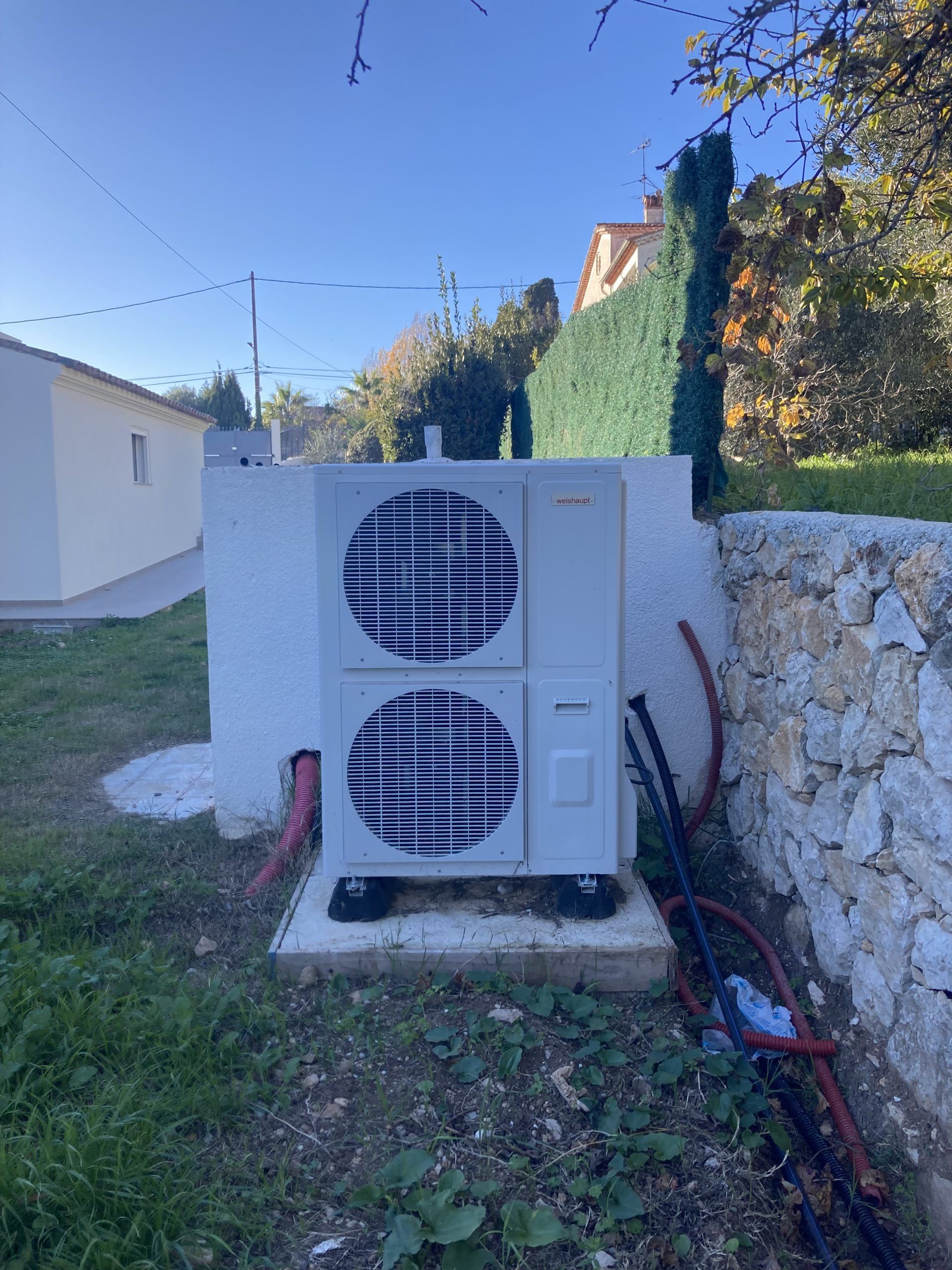 Unité de pompe à chaleur air-air installée dans un jardin.
