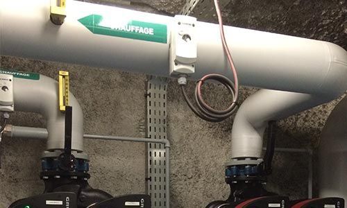 Tuyaux gris étiquetés « chauffage » avec vannes et câblage raccordés.