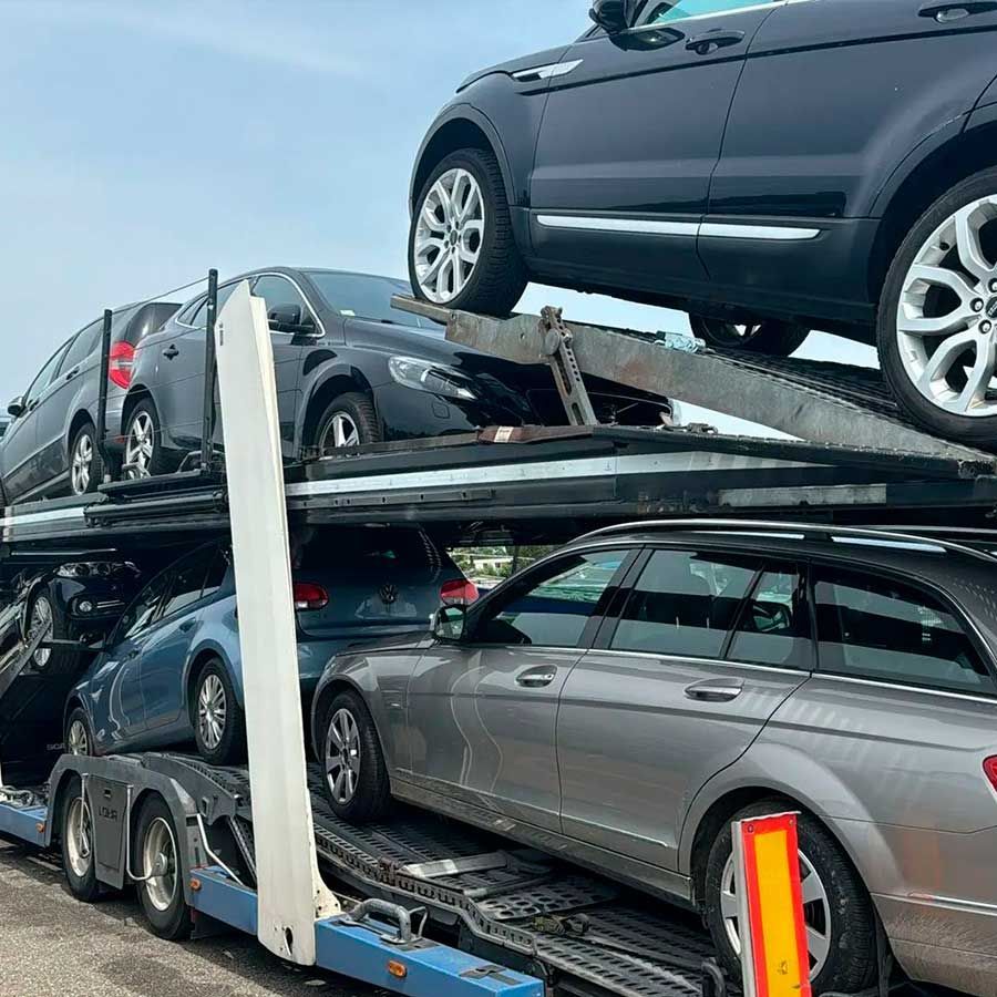 Una fila de coches están sentados uno encima del otro en un remolque.