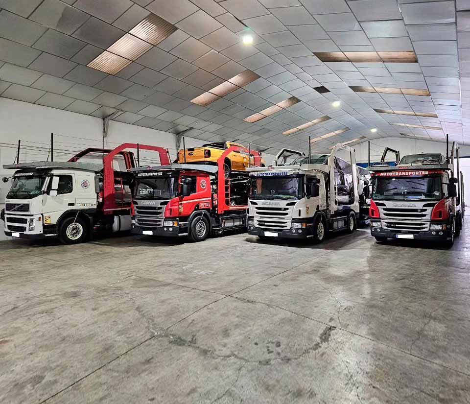Una fila de camiones están estacionados en un almacén