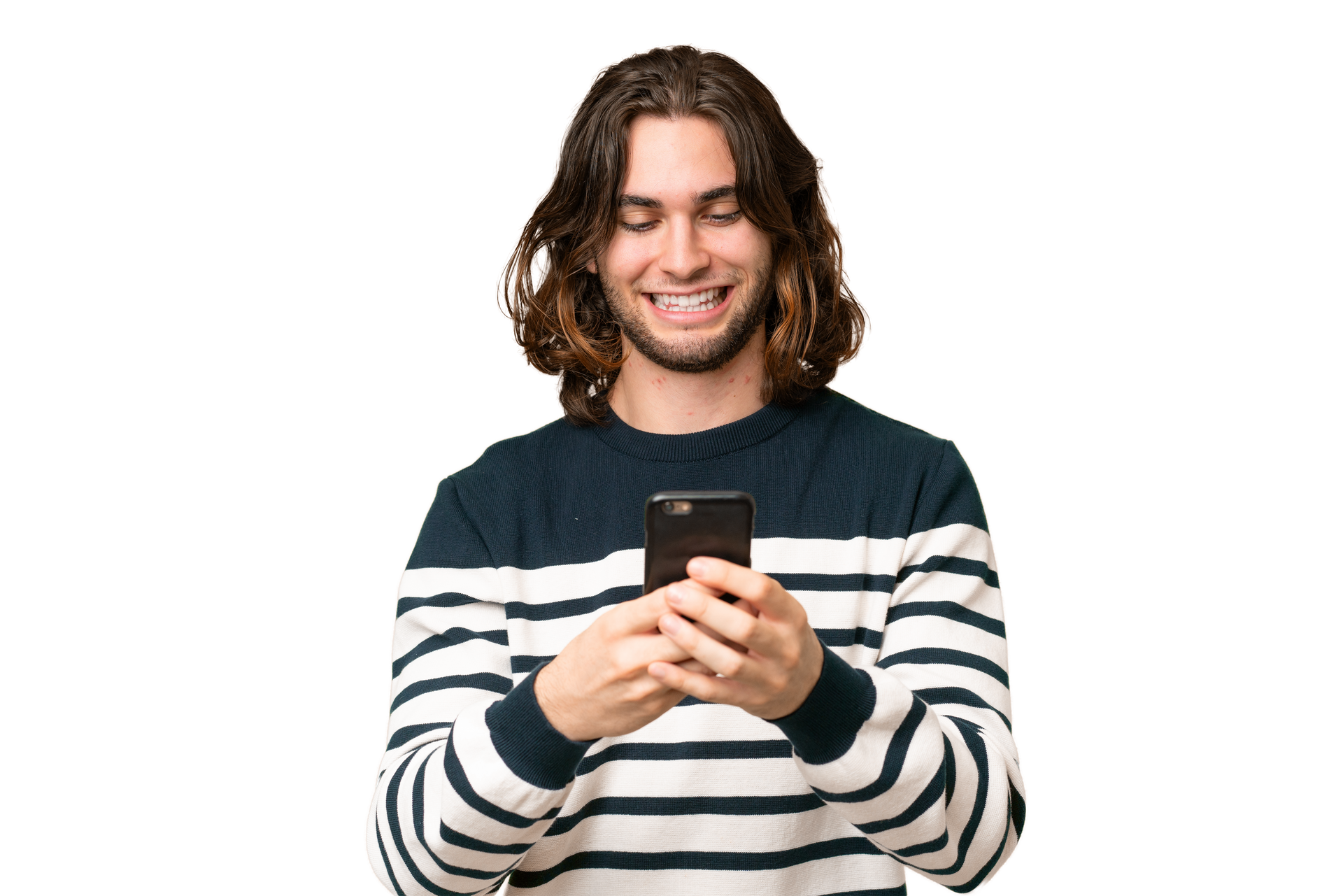 Une personne aux cheveux longs, vêtue d'un pull rayé, sourit en tenant et en regardant un smartphone.