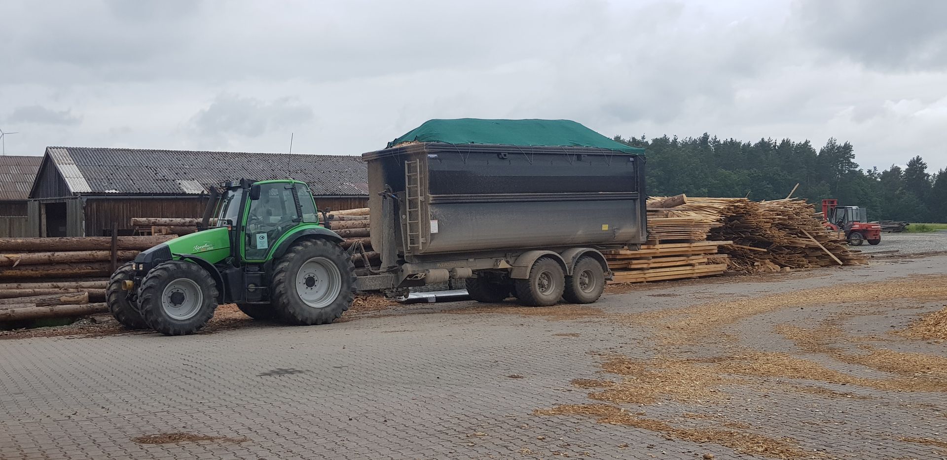 Traktor mit Kippmulde beim Abtransport von Hackschnitzeln