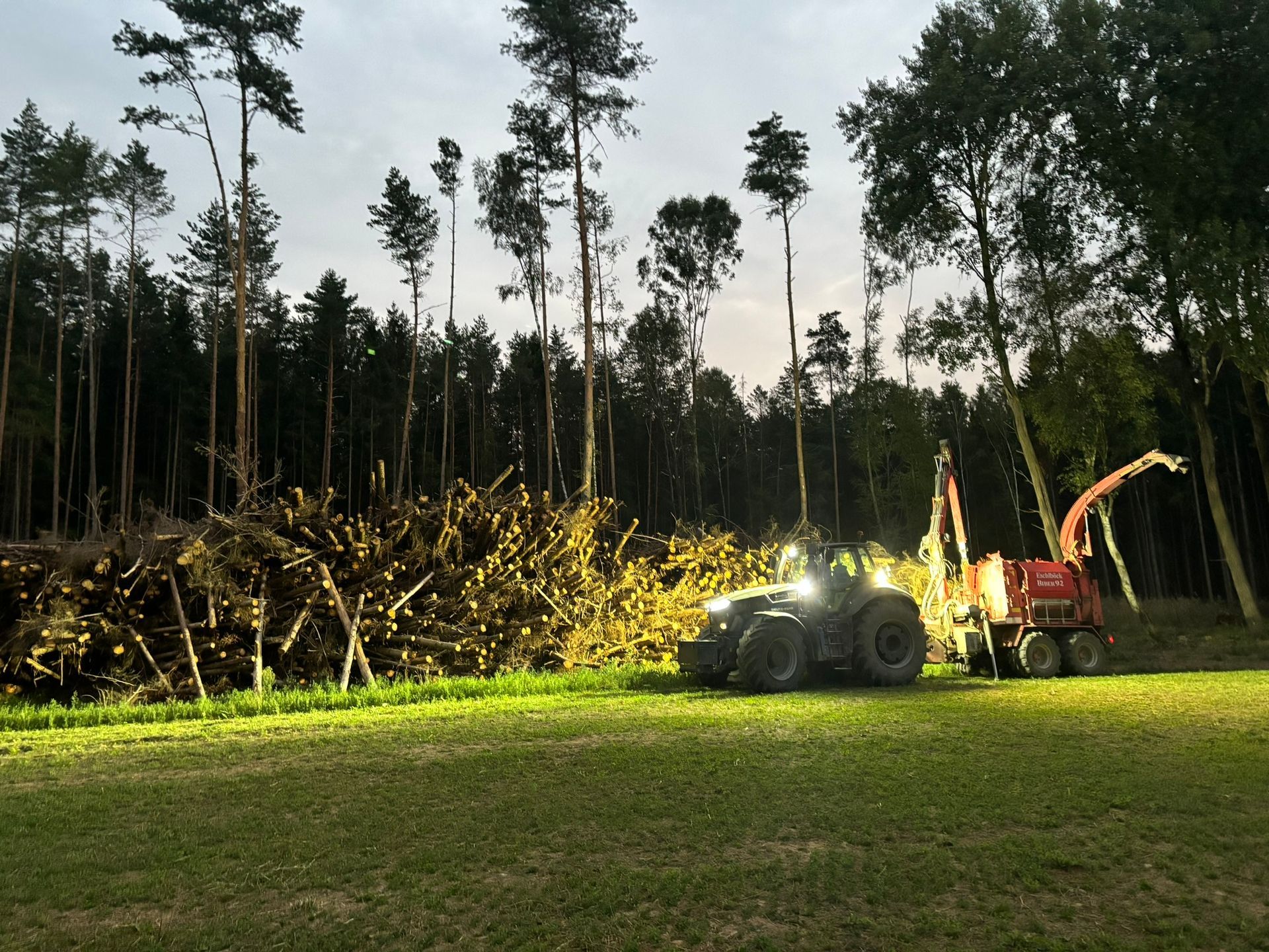 Nachtarbeit mit Holzhacker und Traktor im Wald