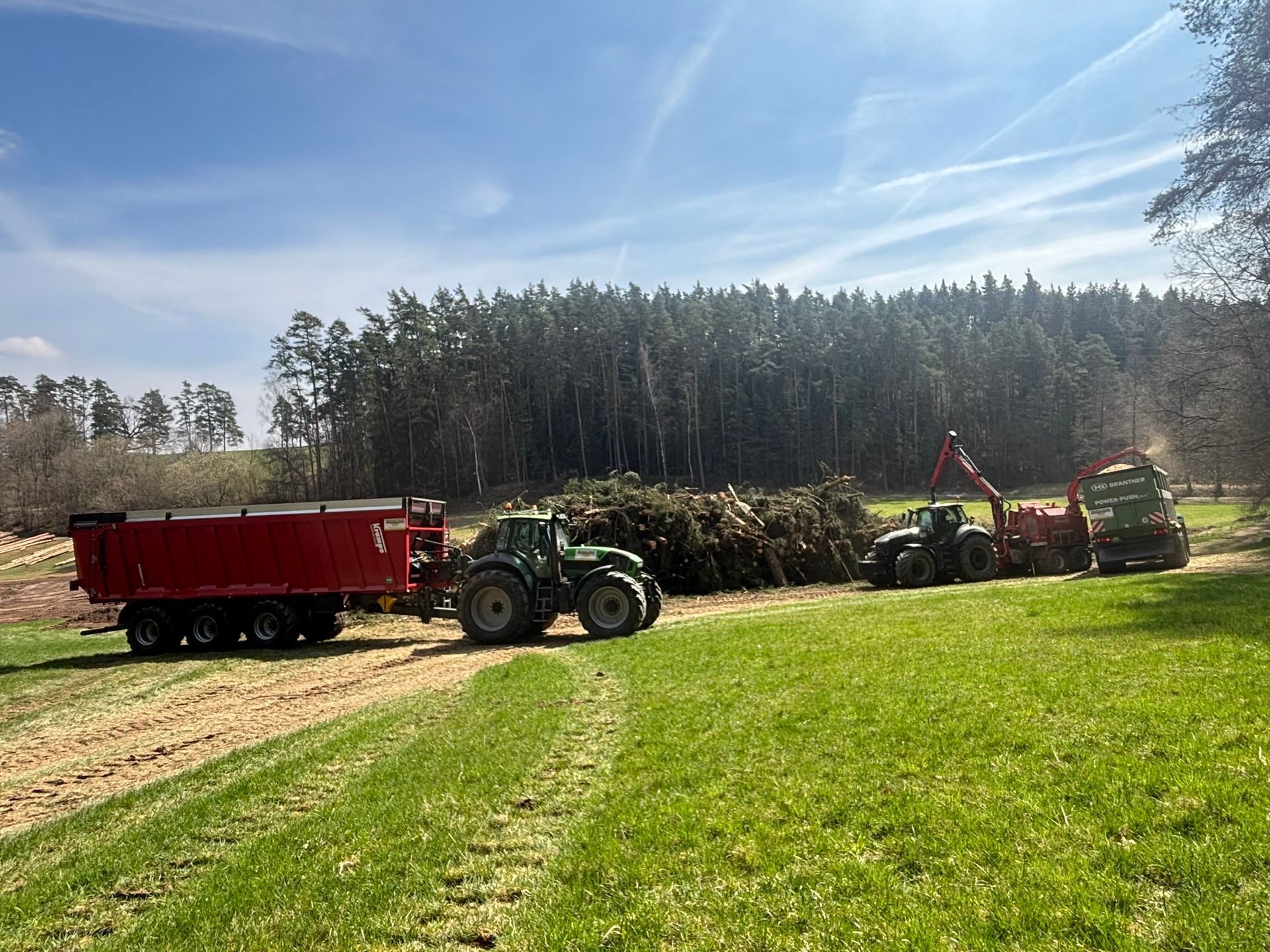 Hackschnitzelernte auf Wiese mit mehreren Traktoren