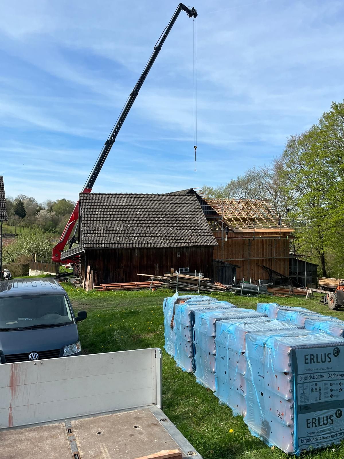 Kran hebt Bauteil bei Dacharbeiten