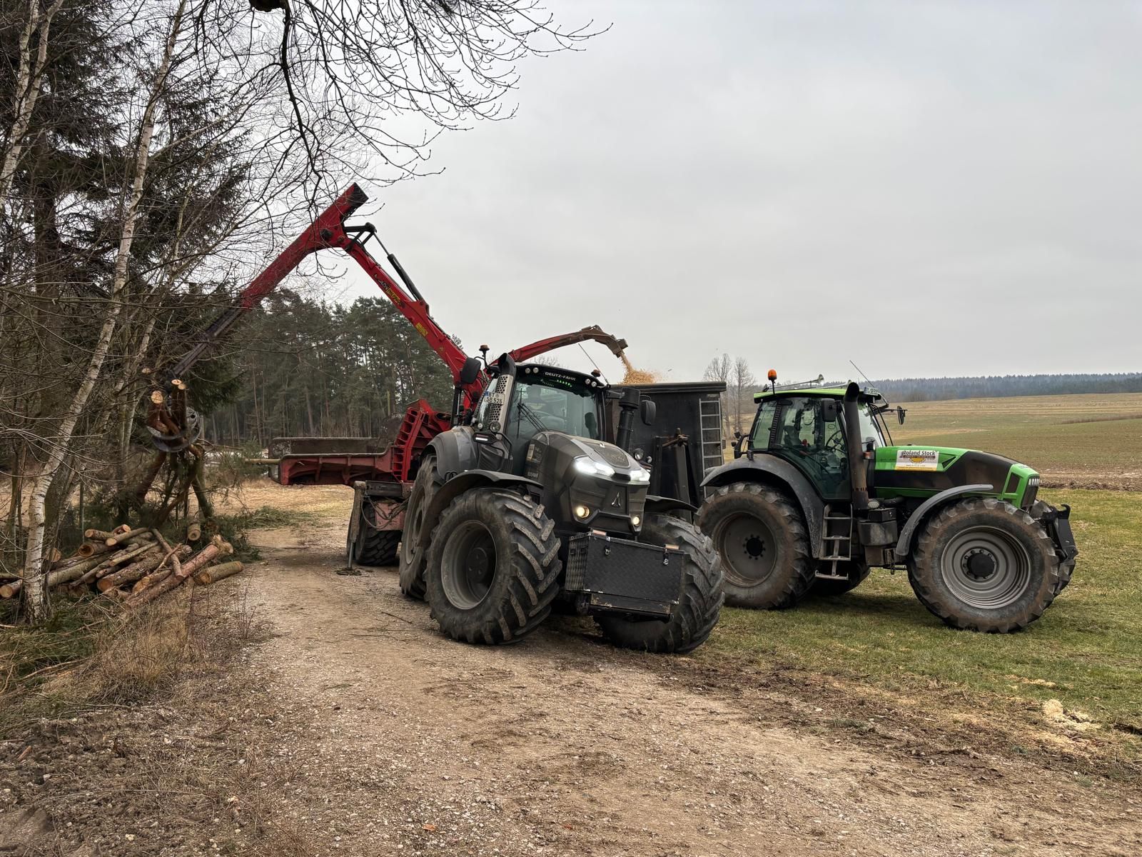 Traktor mit Greifer bei Holzernte am Feldrand