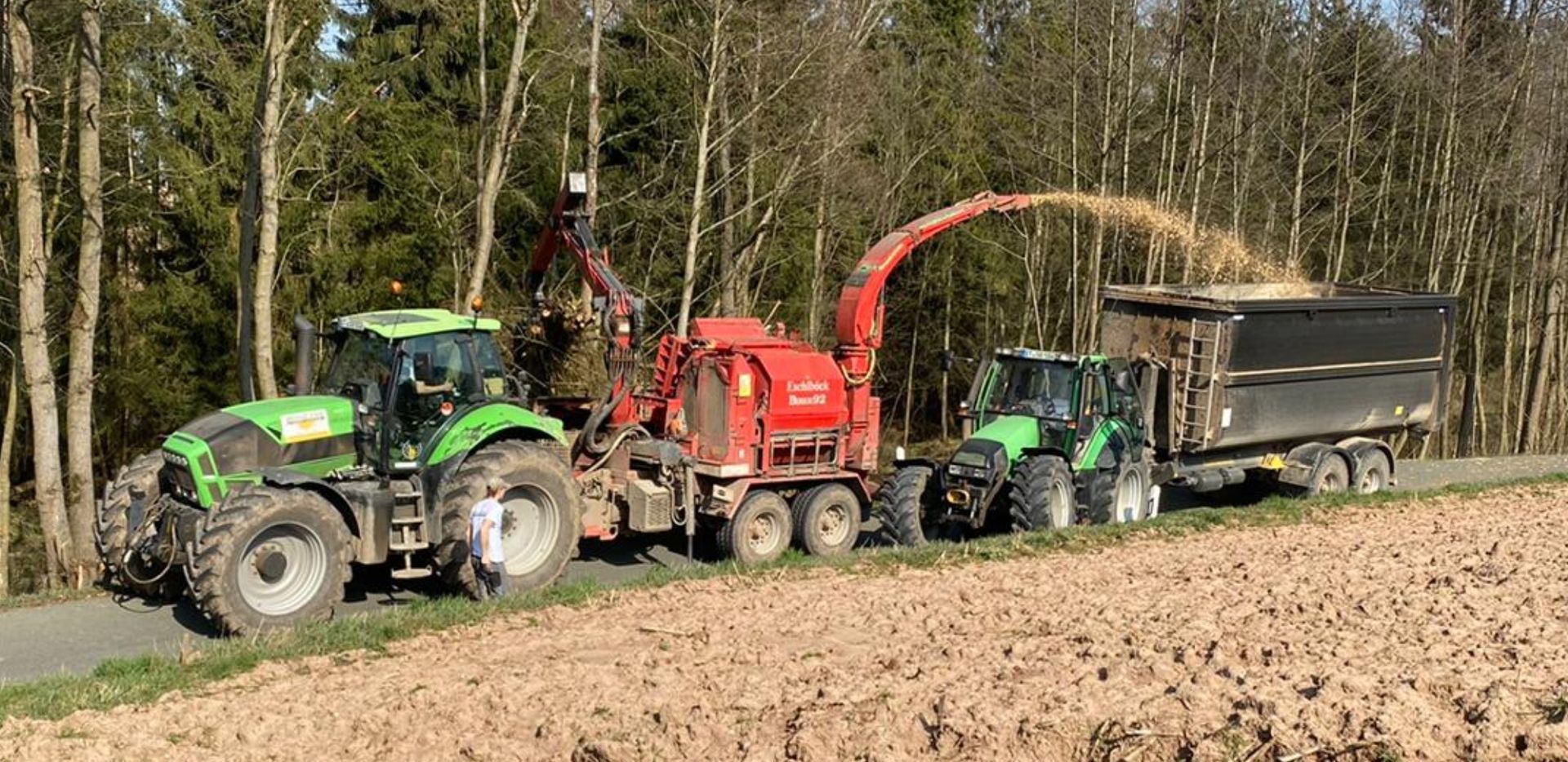 Lohnhacksler im Einsatz mit Traktor und Abfuhrwagen