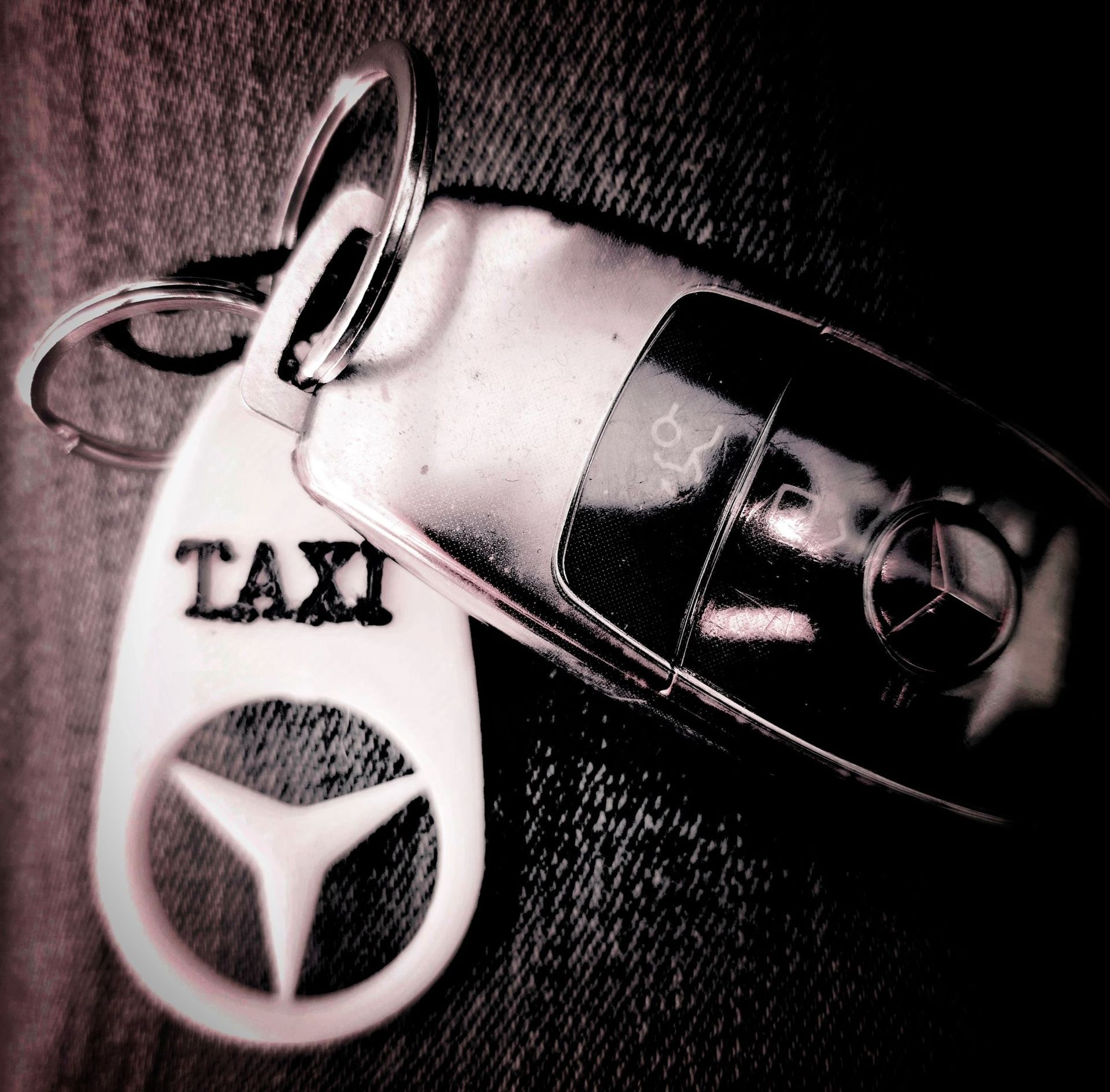 Un llavero que dice taxi junto a la llave de un coche mercedes Benz E220 de Taxi Navalmoral Jesús Picas