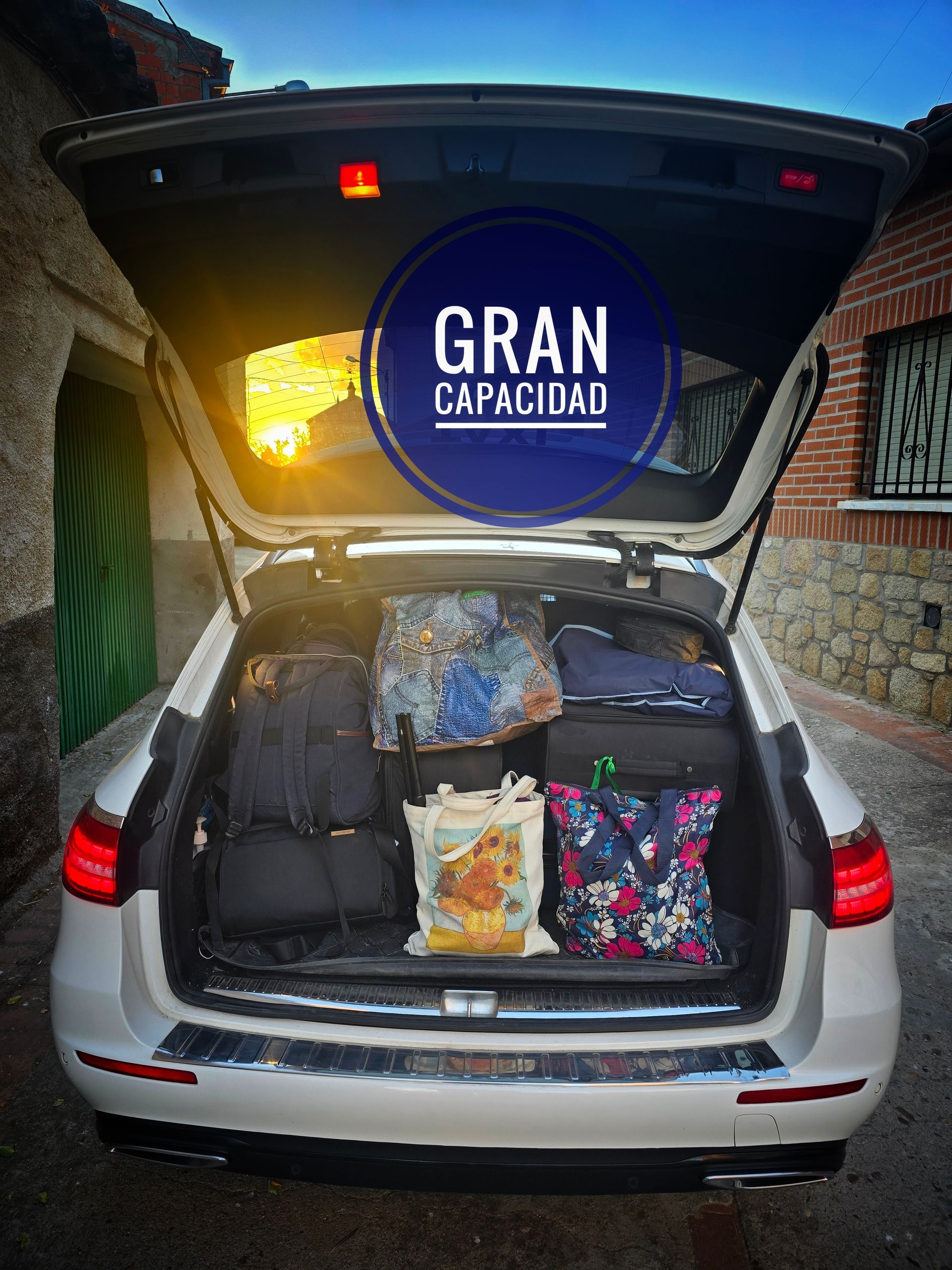 Maletero de Taxi Jesús Picas abierto, lleno de equipaje. Círculo azul con la etiqueta 