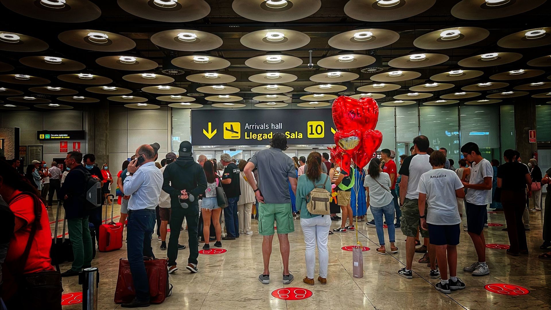 Gente esperando llegada de pasajeros en la Sala 10 de la T1 del aeropuerto Madrid Barajas