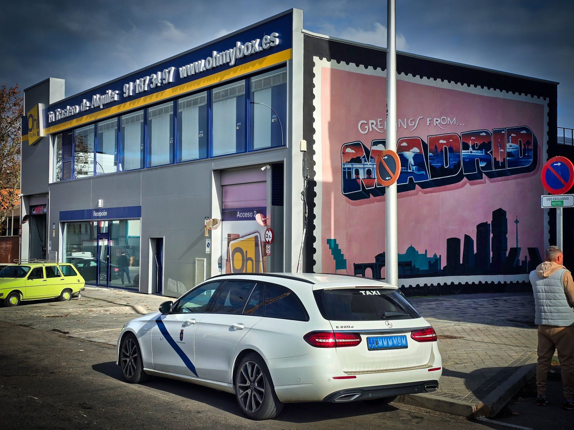 Taxi Mercedes de Navalmoral Jesús Picas en Madrid frente a fachada con grafiti de Madrid