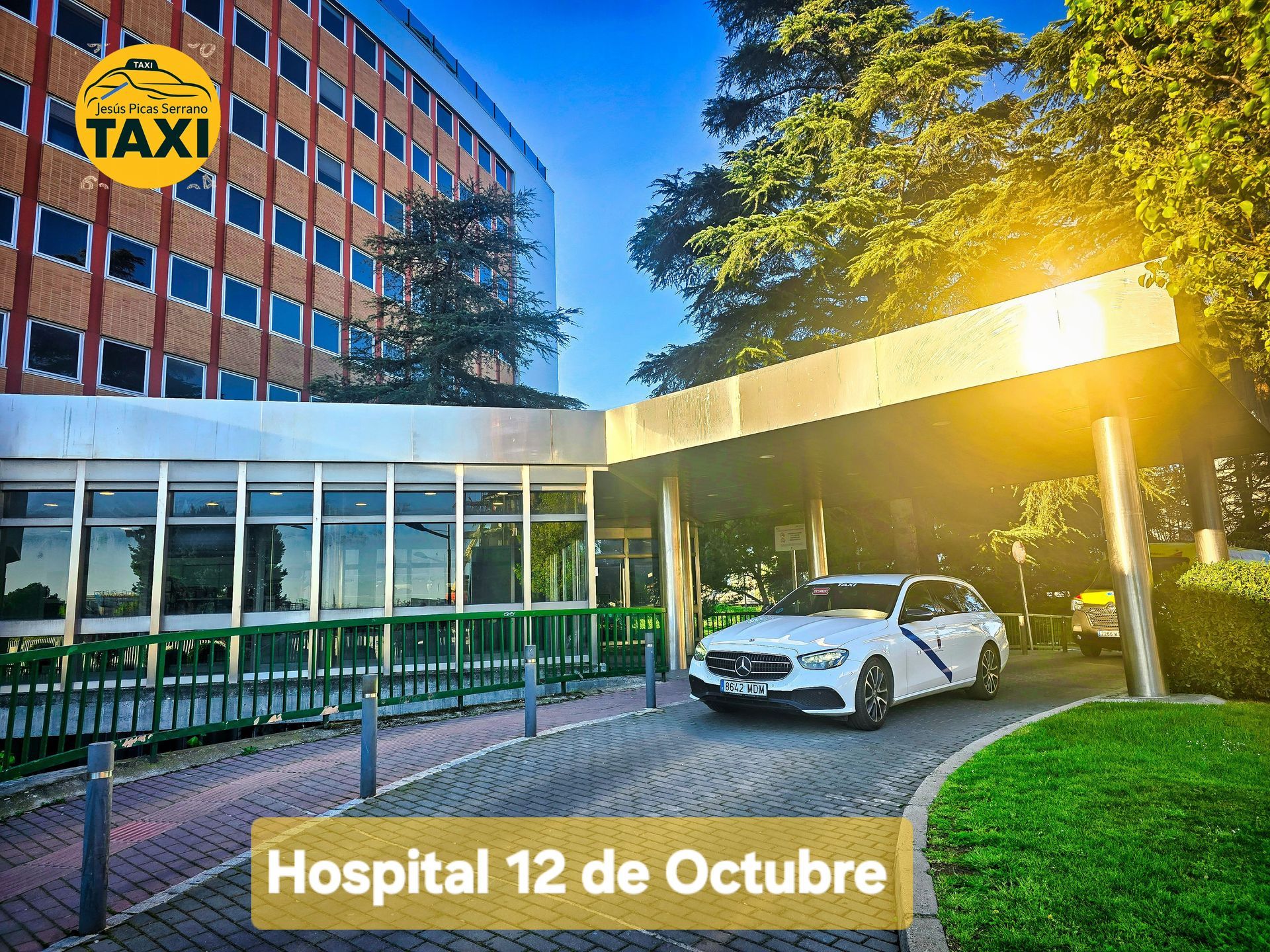 Entrada del Hospital 12 de Octubre con un taxi Navalmoral Jesús Picas estacionado afuera, al sol.
