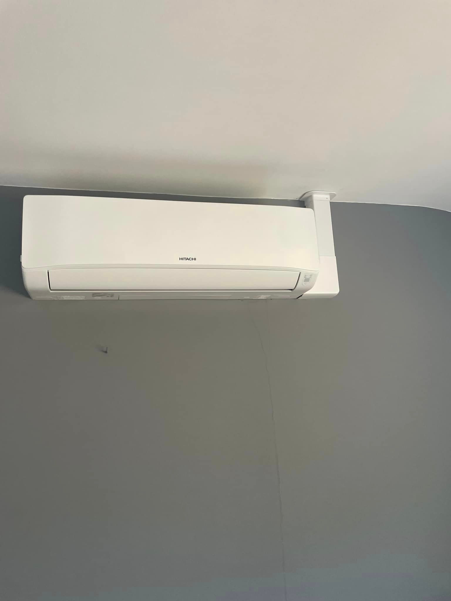 Un climatiseur installé en haut d'un mur vu de face