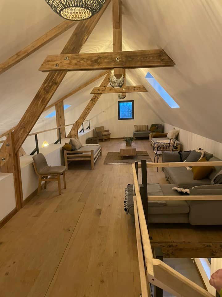 Une pièce avec de la charpente apparente au plafond