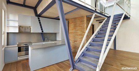 Une cuisine à l'américaine ouverte sur un escalier menant à l'étage