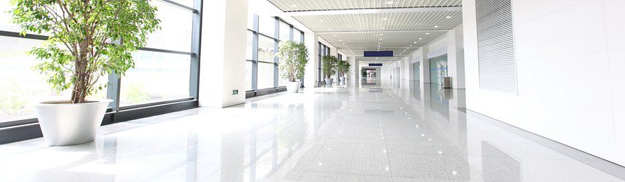 Hall de bâtiment aux tons clairs avec carrelage en marbre blanc