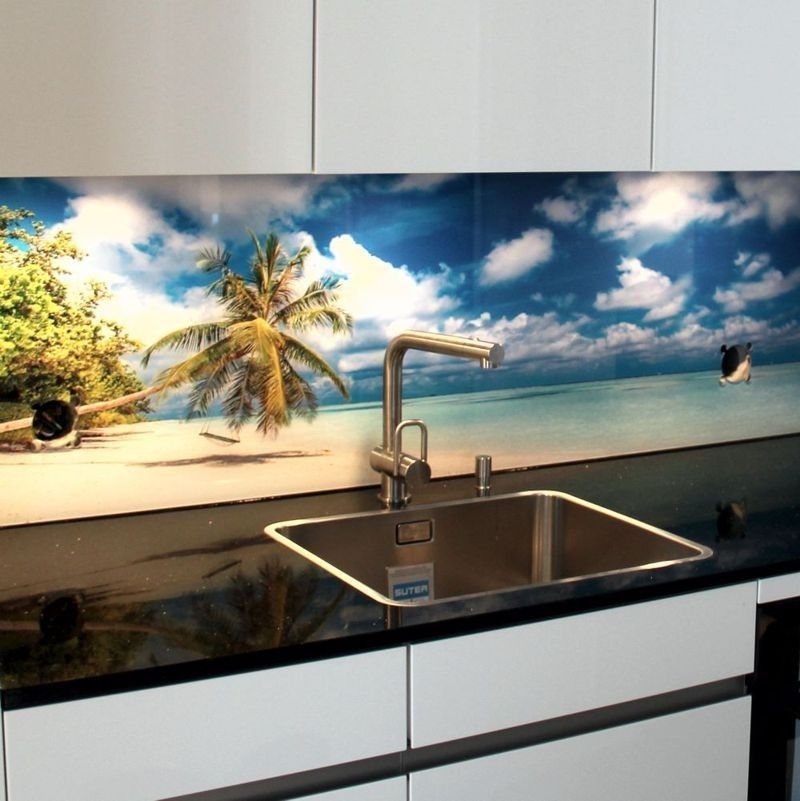 Küchenspüle mit tropischem Strandmotiv als Spritzschutz. Das Motiv zeigt eine Palme, blauen Himmel und weiße Wolken.
