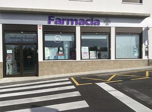 El frente de una farmacia con un paso de peatones enfrente.