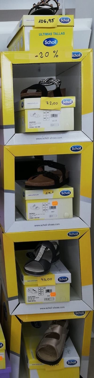 Una pila de cajas amarillas llenas de zapatos en un estante.