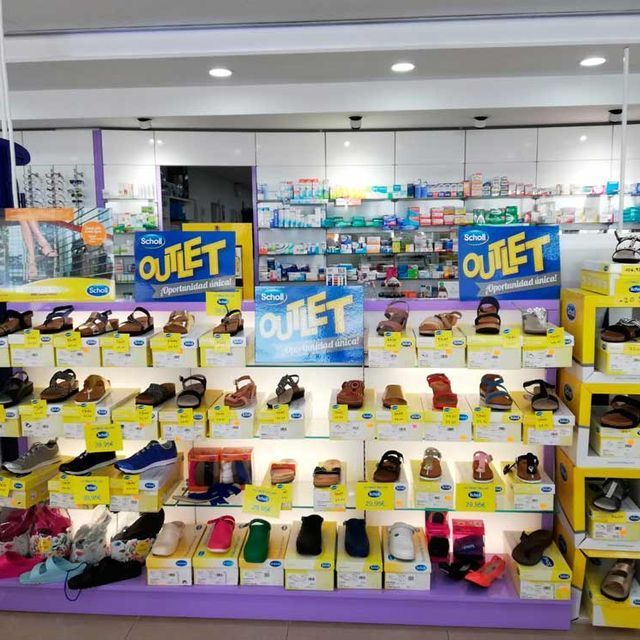 Una exhibición de zapatos en una tienda con carteles que dicen outlet