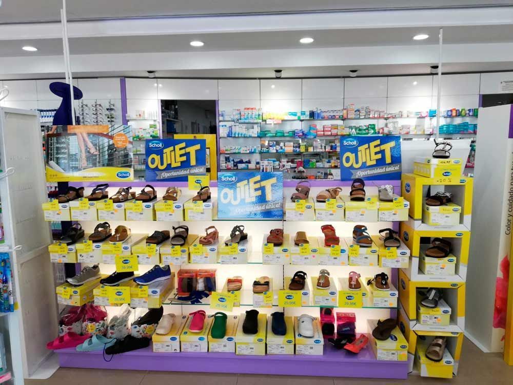 Una exhibición de zapatos en una tienda con carteles que dicen outlet.
