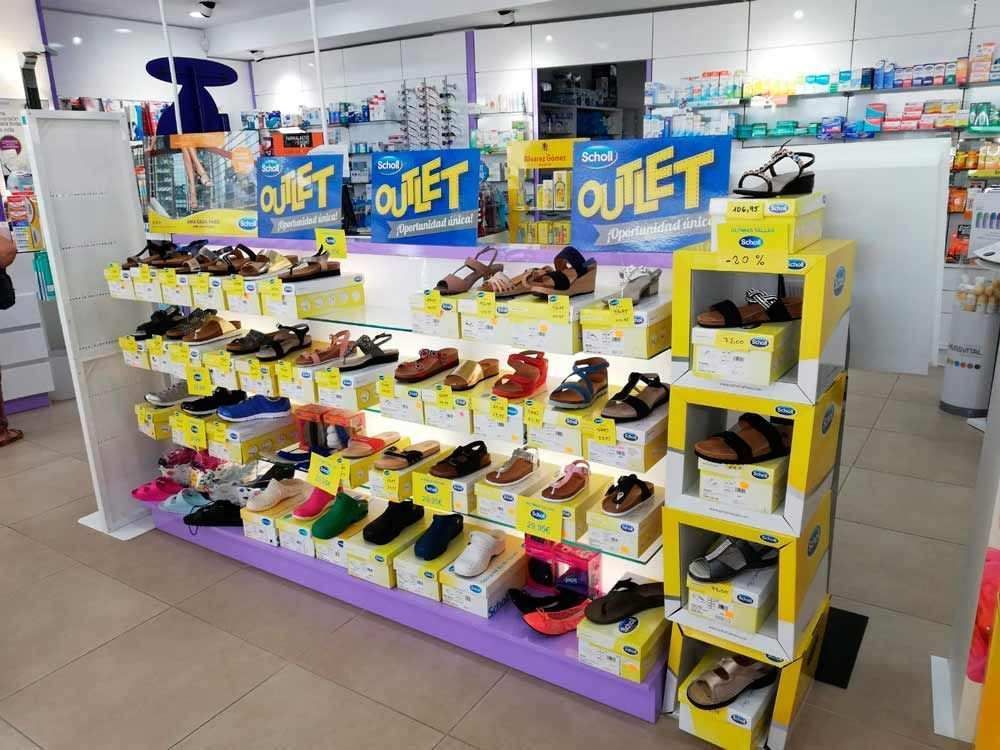 Una exhibición de zapatos en una tienda con un cartel que dice 