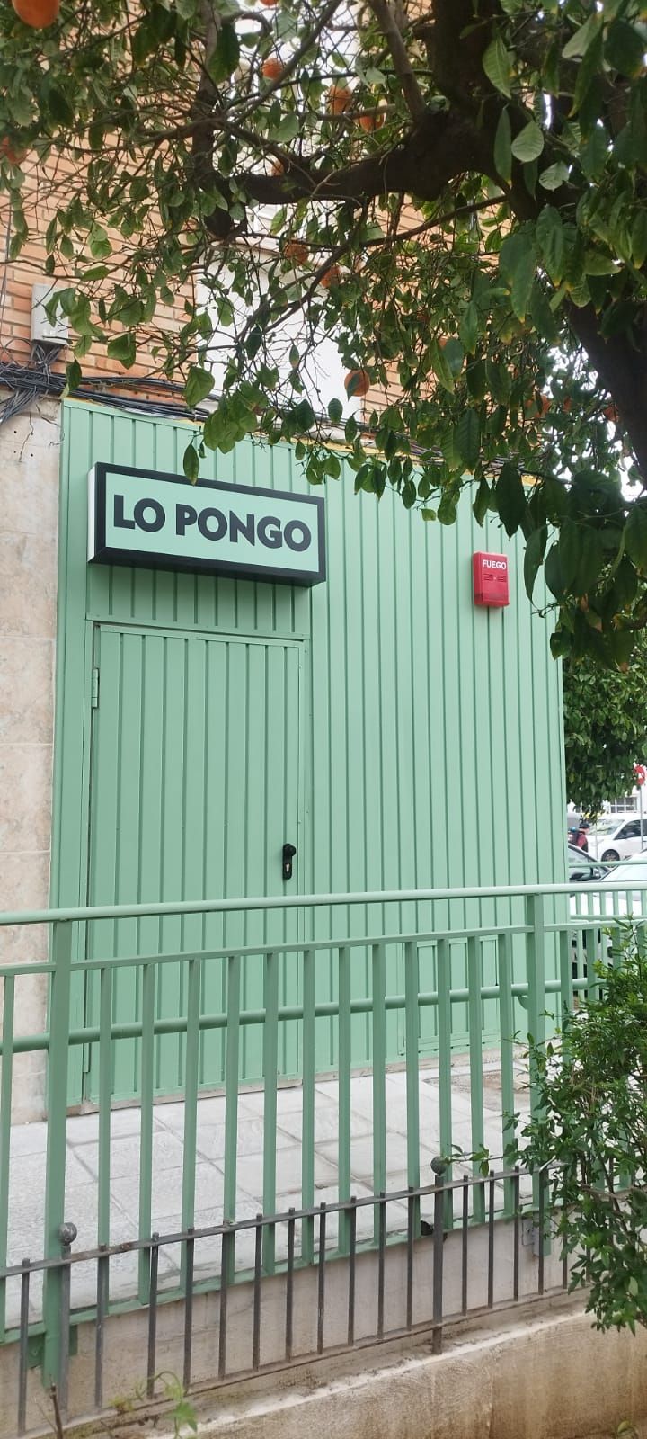 Edificio verde con un cartel que dice