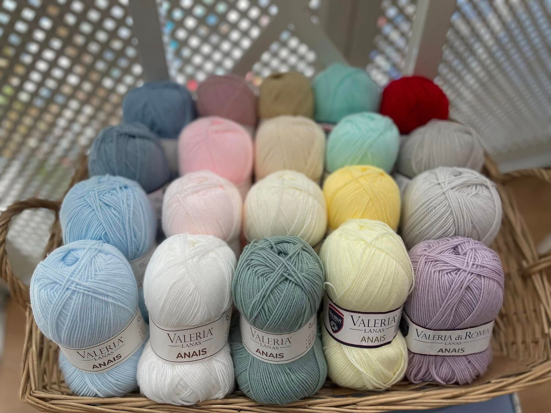 Una cesta llena de bolas de hilo de diferentes colores.