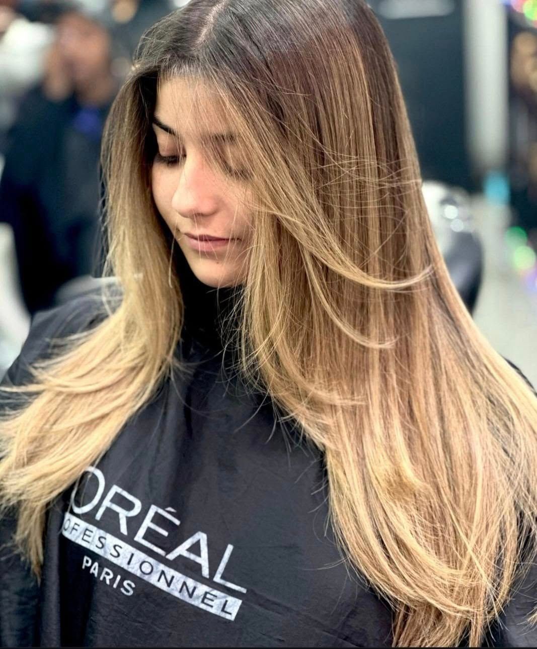 Una mujer con cabello largo y rubio lleva una capa negra.