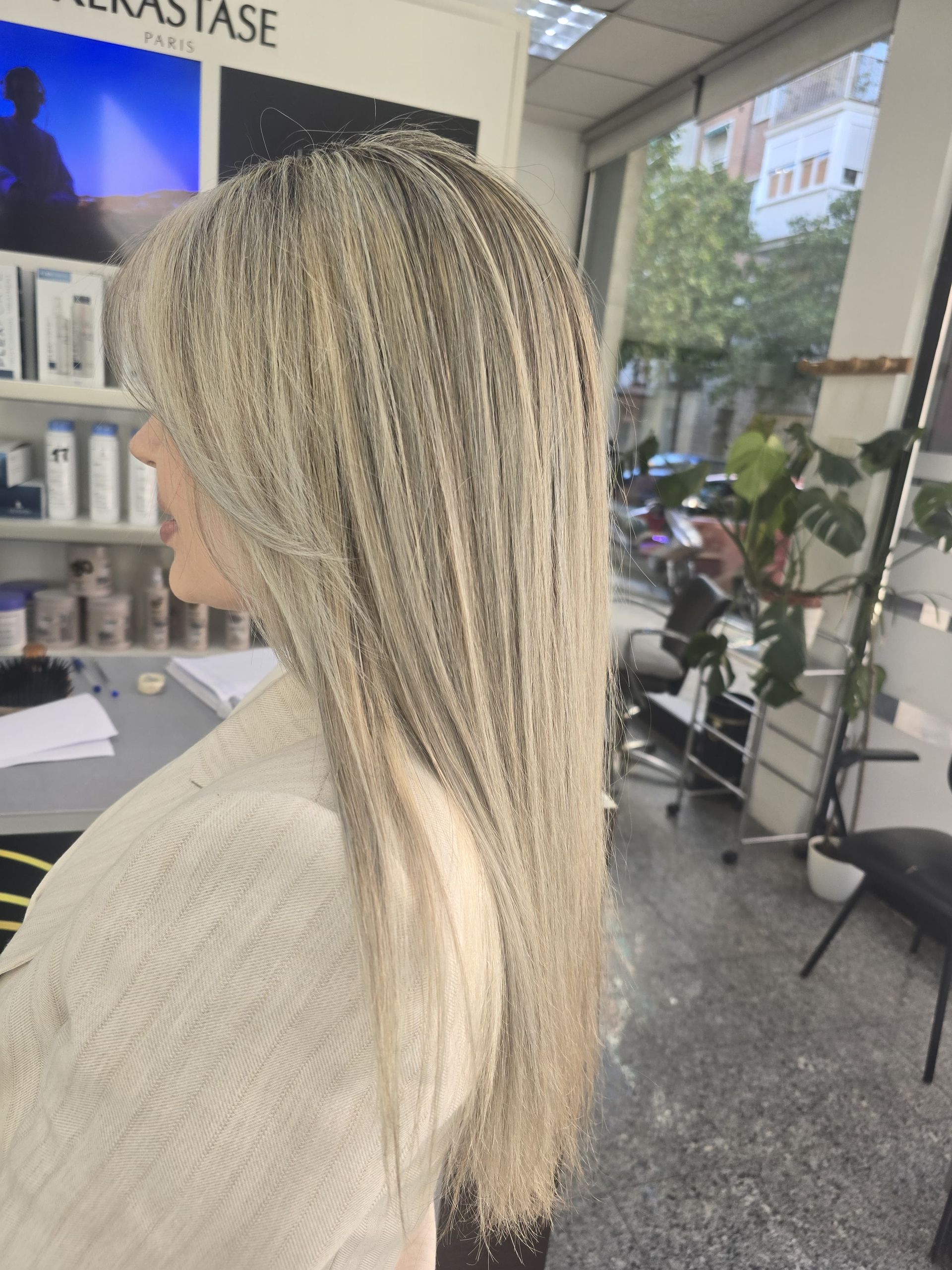 Una mujer con cabello largo y rubio está sentada en un salón.