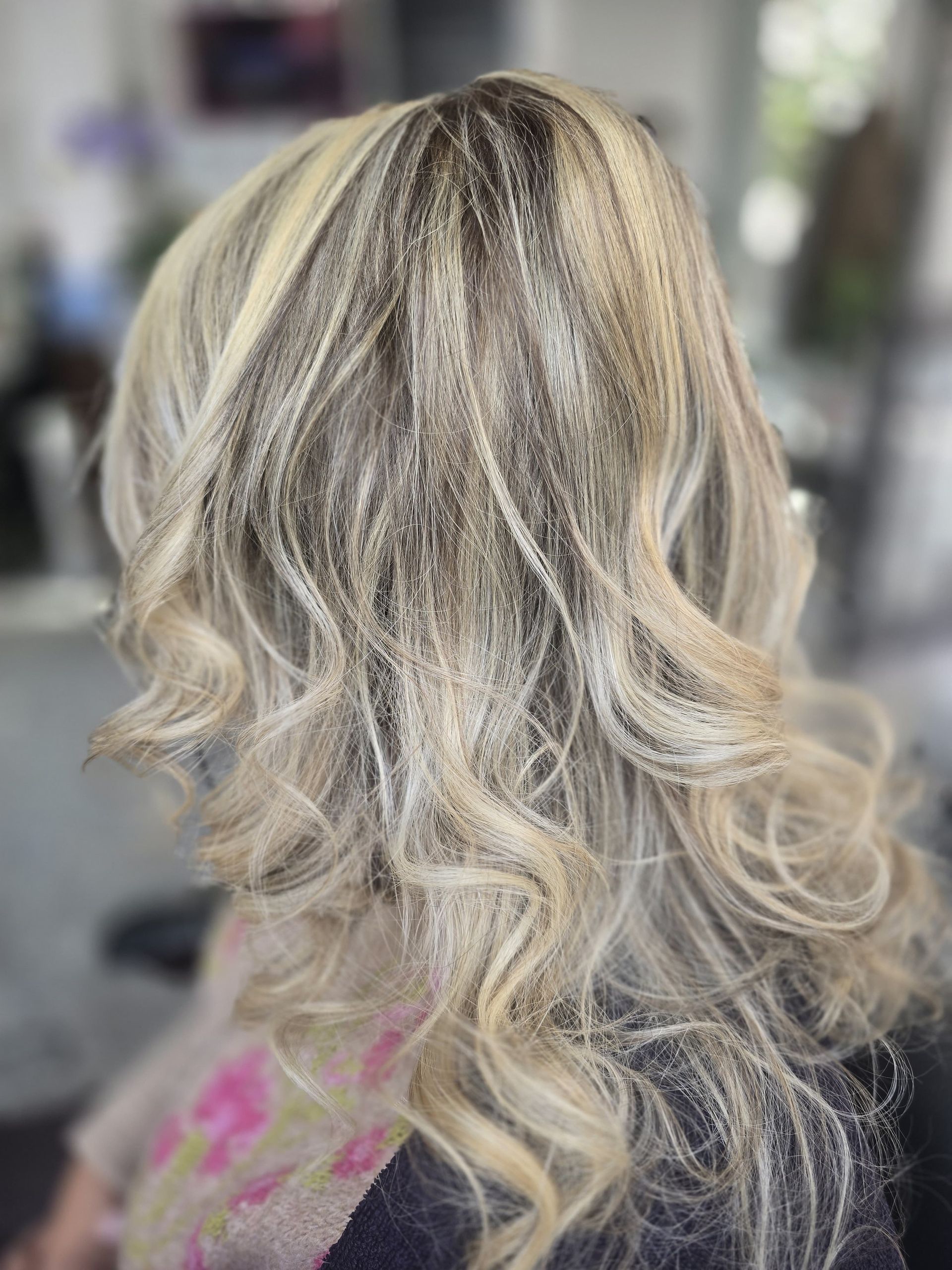 Un primer plano del cabello rubio de una mujer en un salón.