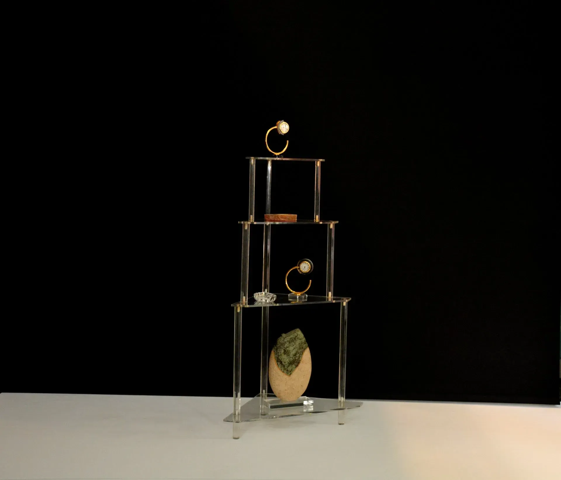 Una pila de estantes de acrílico transparente con anillos en ellos.