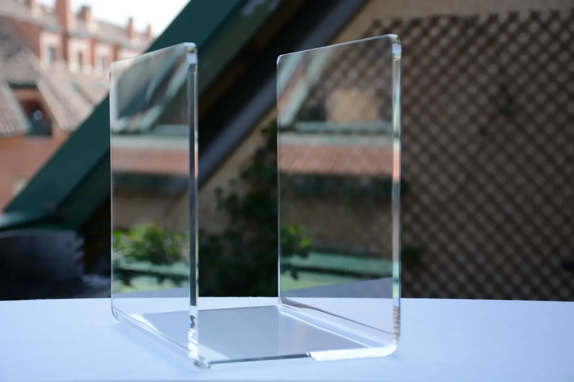 Un bloque de acrílico transparente está sobre una mesa frente a una ventana.