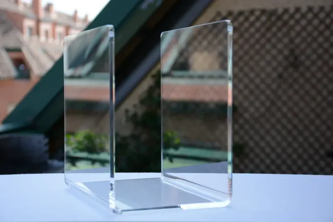 Un bloque de acrílico transparente está sobre una mesa frente a una ventana.