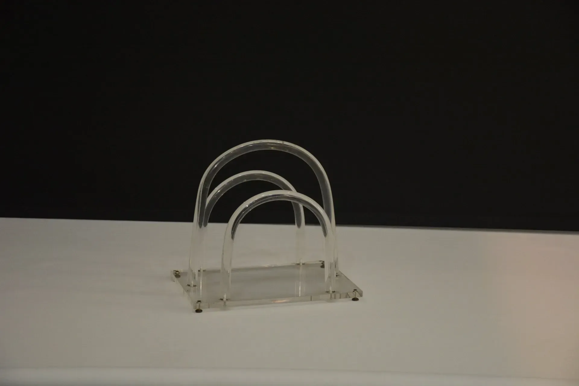 Un servilletero de acrílico transparente está sobre una mesa blanca.