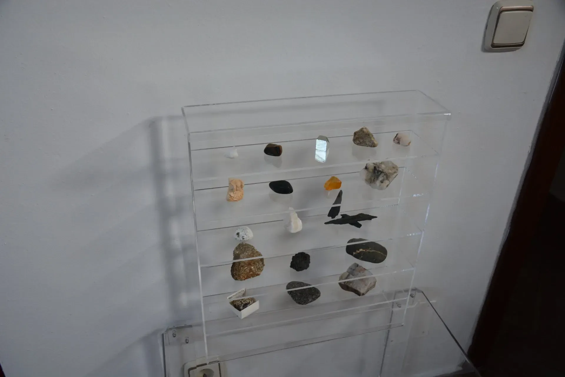 Una vitrina transparente llena de piedras sobre una mesa.