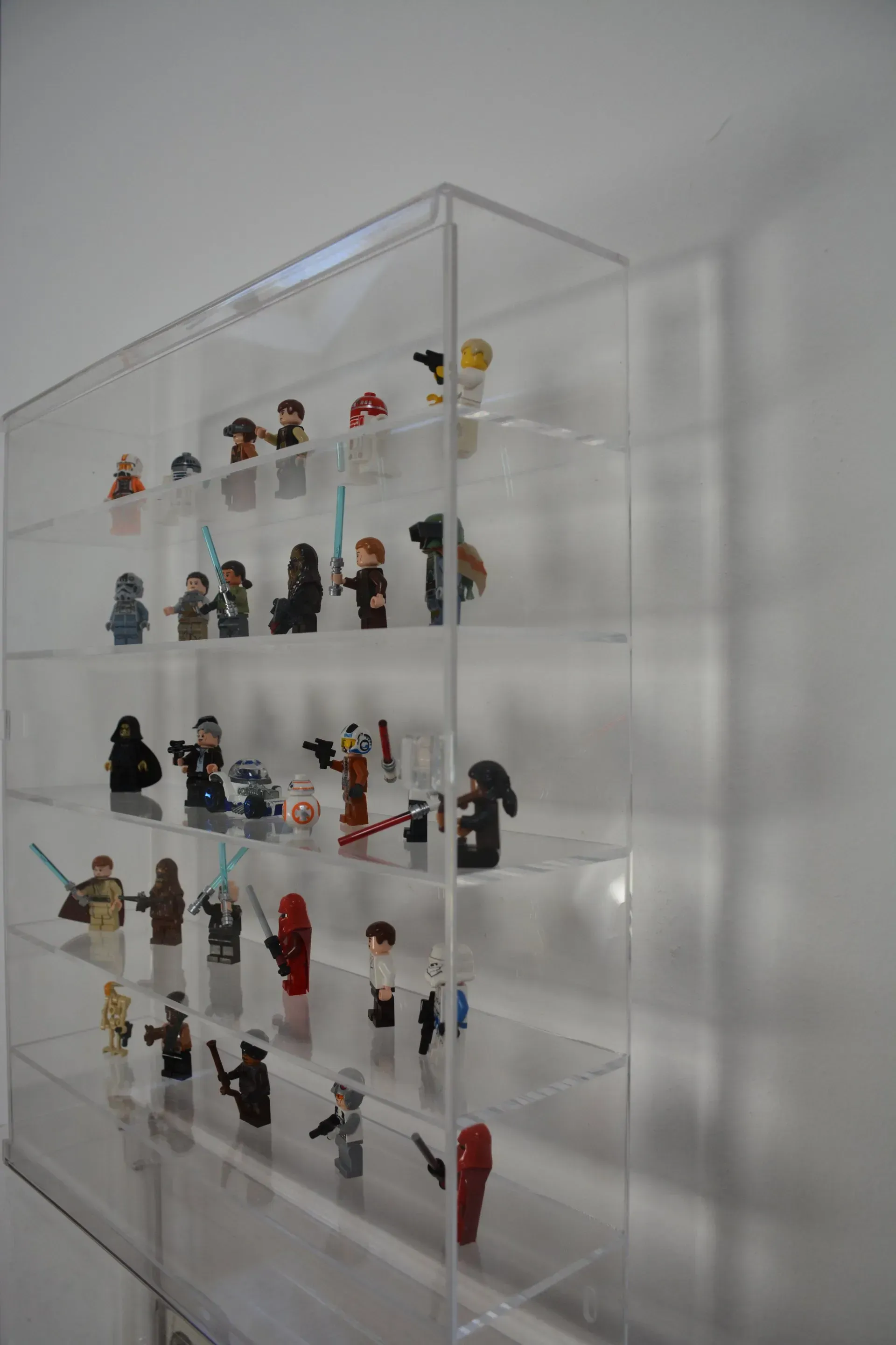 Una vitrina transparente llena de muchas figuras de Lego.