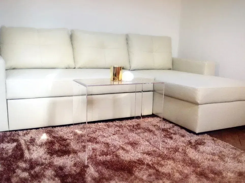 Una sala de estar con un sofá blanco y una alfombra marrón.