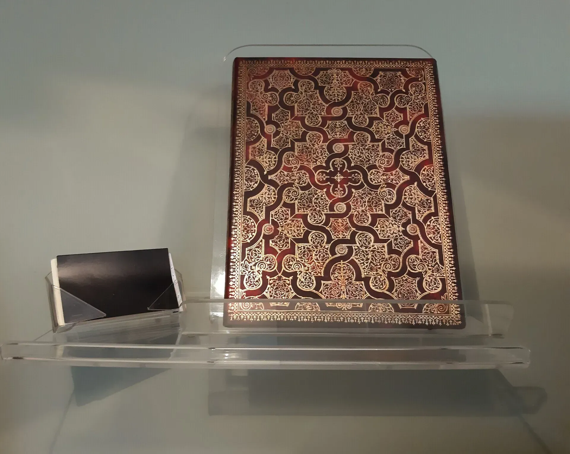 Un libro que se encuentra encima de un estante vacío