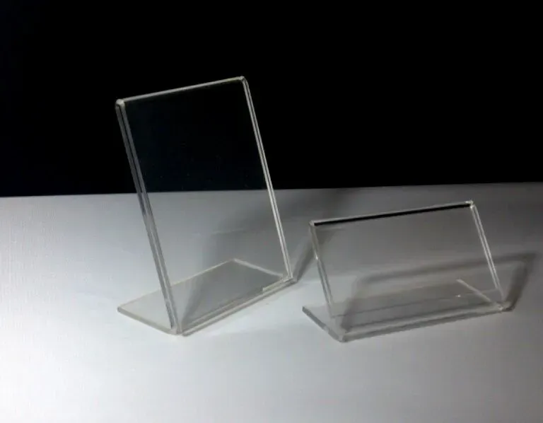 Dos expositores de acrílico transparente se encuentran sobre una mesa blanca.