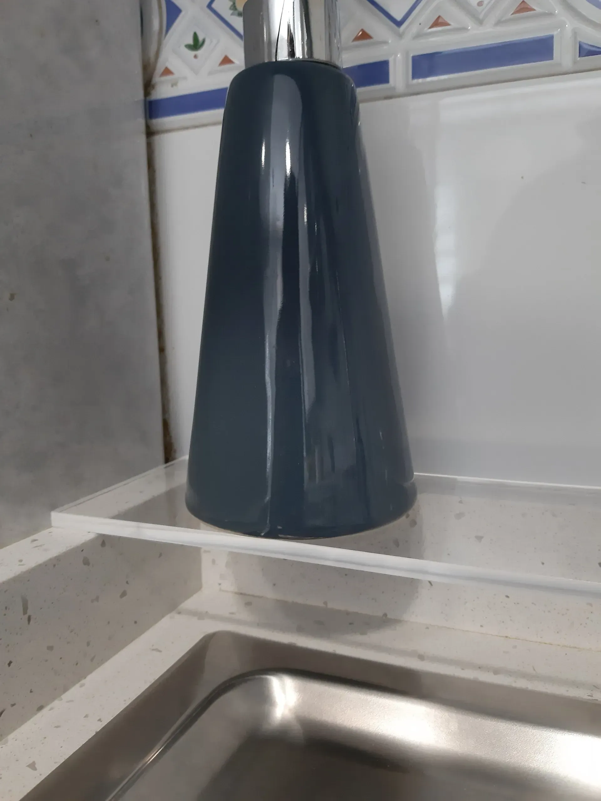 Un lavabo con un dispensador de jabón encima.