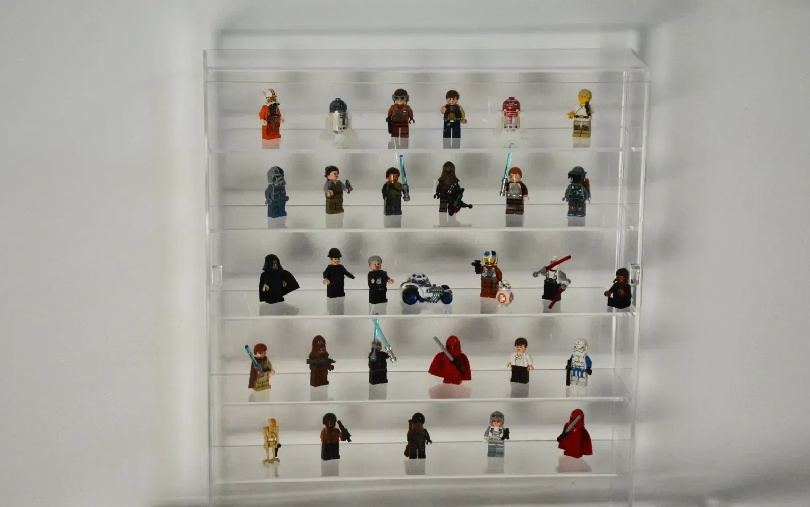 Una vitrina transparente llena de muchas figuras de Lego.