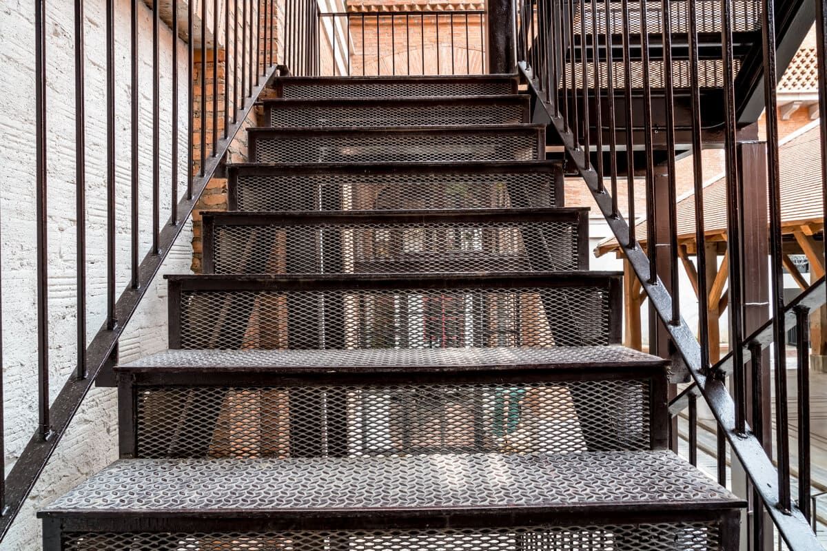 Un primer plano de un conjunto de escaleras de metal con una barandilla de metal.