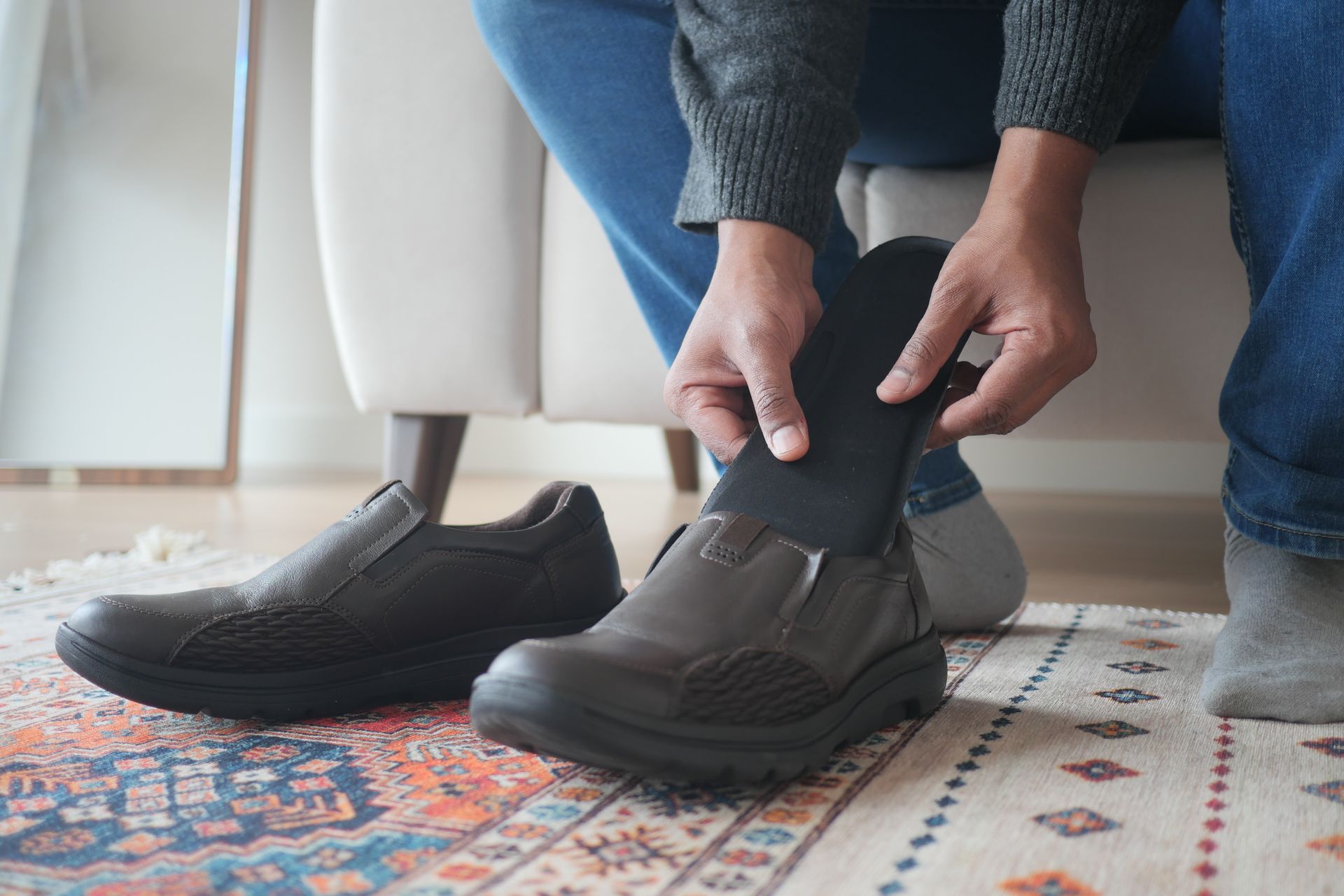 Homme insérant une semelle orthopédique dans ses chaussures en gros plan