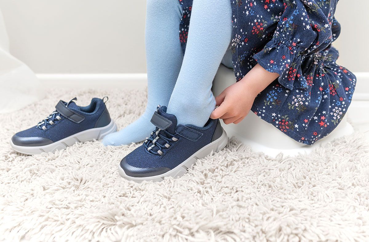 Jeune enfant enfilant une paire de basket moderne