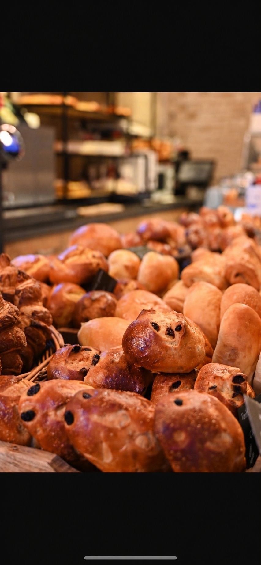 Plateau de viennoiseries et de pains assortis dans une vitrine de boulangerie