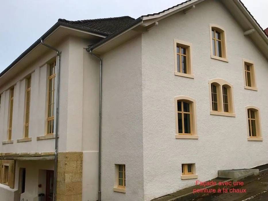 Un grand bâtiment blanc avec beaucoup de fenêtres | Giovannini Plâtrerie-Peinture Sàrl