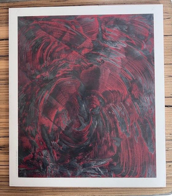 Un tableau rouge et noir est posé sur une table en bois | Giovannini Plâtrerie-Peinture Sàrl