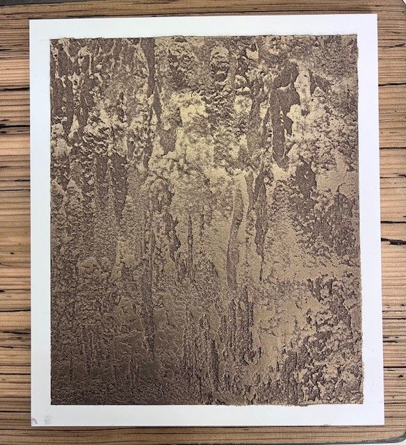 Un tableau marron et blanc est posé sur une table en bois | Giovannini Plâtrerie-Peinture Sàrl